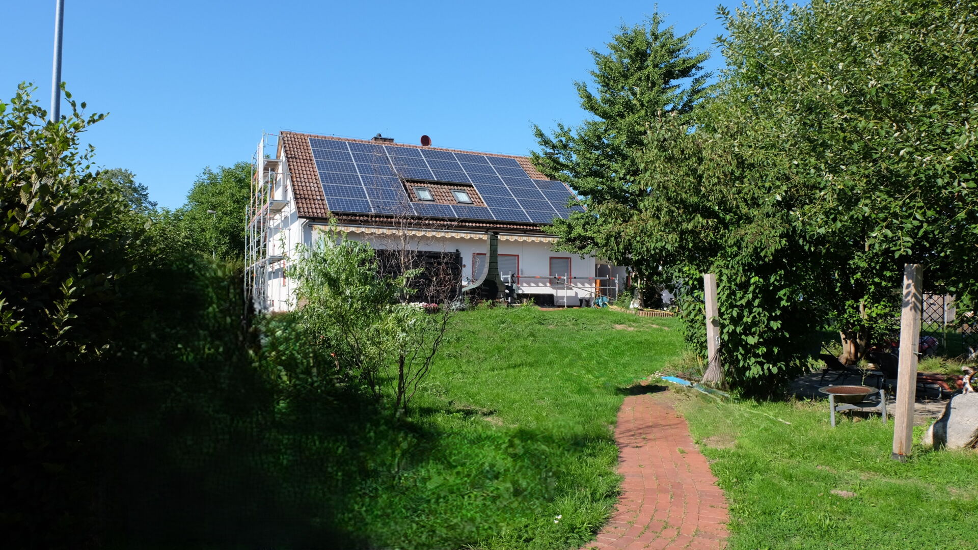 Mehrfamilienhaus - Ansicht von der Gartenseite mit Solarplatten auf dem Dach