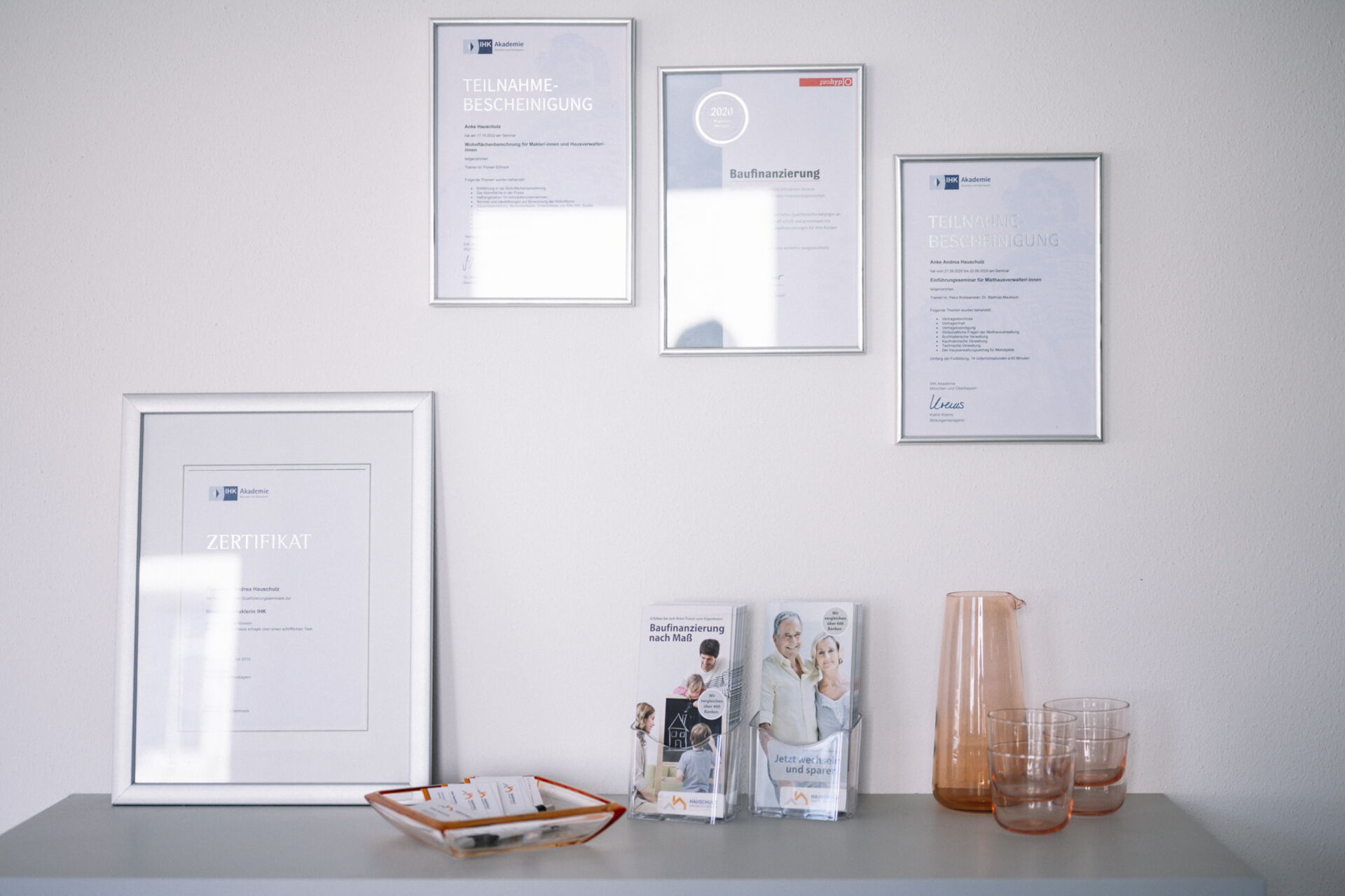 Bürowand mit vier gerahmten Zertifikaten für geprüfte Immobilienmakler & Dekoration